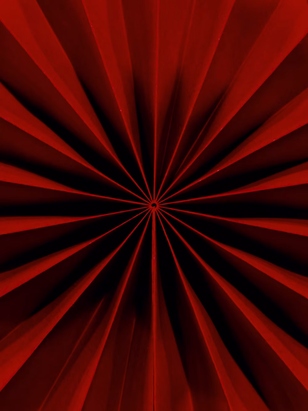 Abstract Red Radial Paper Fan Pattern — Geometric Starburst Design With Dramatic Shadows