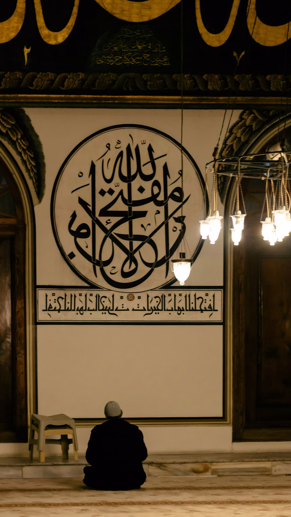 Quiet Devotion Beneath Sacred Calligraphy