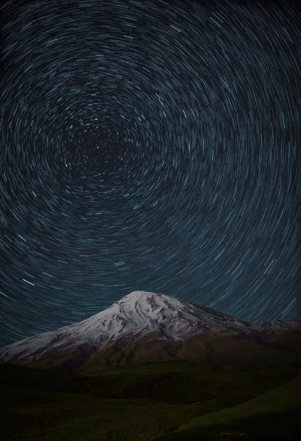 Snow-Capped Mountain Under Star Trails Night Sky Long Exposure Circular Celestial Motion Over Peak